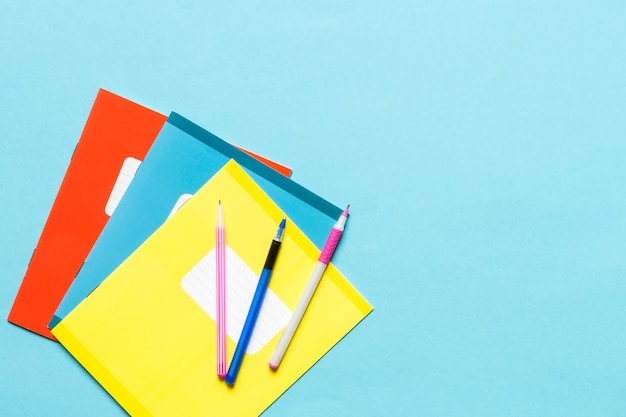 Photo accessoires pour l'école, cahiers, stylos, crayons pour le travail d'un écolier sur fond bleu