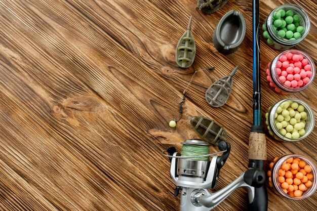 Accessoires pour la pêche à la carpe et les appâts de pêche sur des planches de bois avec espace de copie.