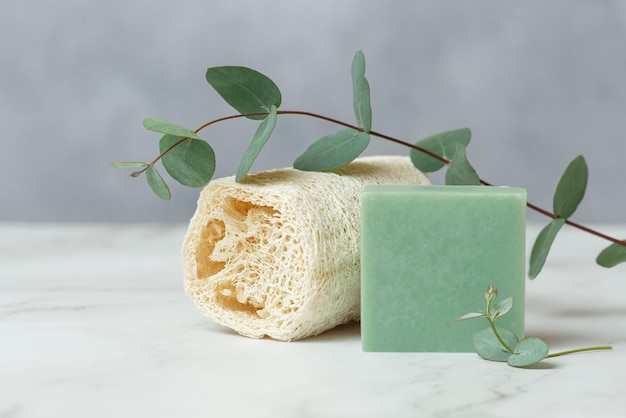 Accessoires pour soins du corps à partir de matériaux naturels sur fond gris Savon naturel avec tampons en coton et brosses en bois