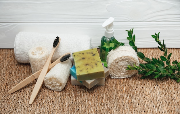 Accessoires de salle de bain et d'hygiène écologiques. Brosses à dents en bambou, serviette blanche, éponge luffa, savon bio fait main avec plante verte. Beauté, concept de traitement SPA.