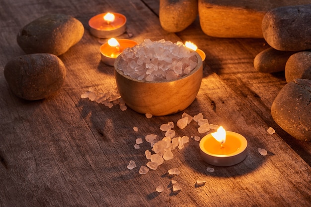 Accessoires de spa. Des brins d'arbre de Noël, de nombreux morceaux de savon multicolores, de nombreuses formes de bouteilles différentes pour une salle de bain. Gommage du corps. Brique légère et bois blanc en arrière-plan