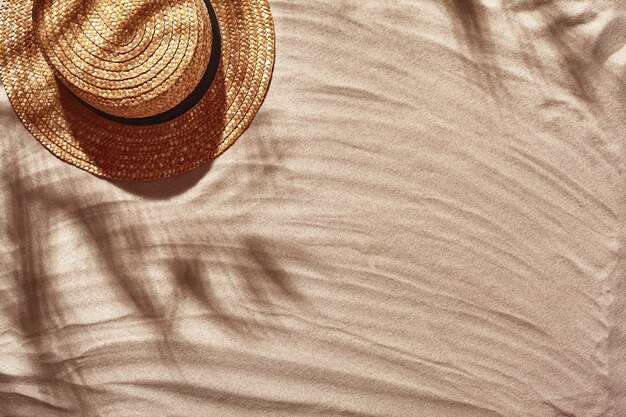 Les accessoires de vacances des voyageurs sont disposés sur une plage de sable blanc vue de dessus à plat