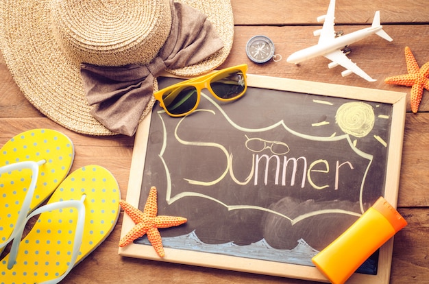 Photo accessoires de voyage de mer un chapeau, lunettes de soleil, appareil-photo. placé sur bois avec le mot 'été