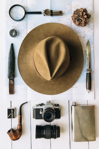 Accessoires de voyage ou de randonnée hipster vintage à plat avec chapeau et appareil photo