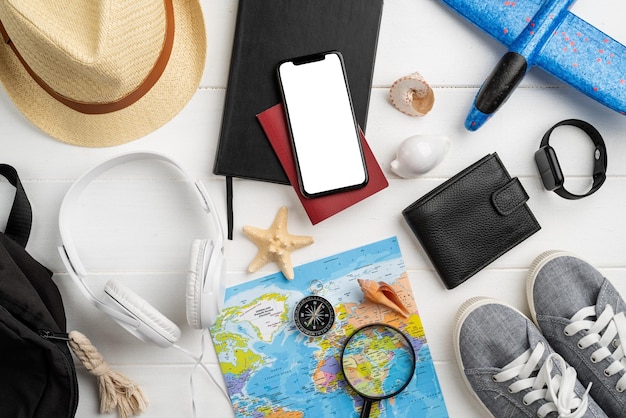 Accessoires de voyage vue de dessus avec carte de chaussures smartphone avec chapeau d'écran maquette Essentiels touristiques