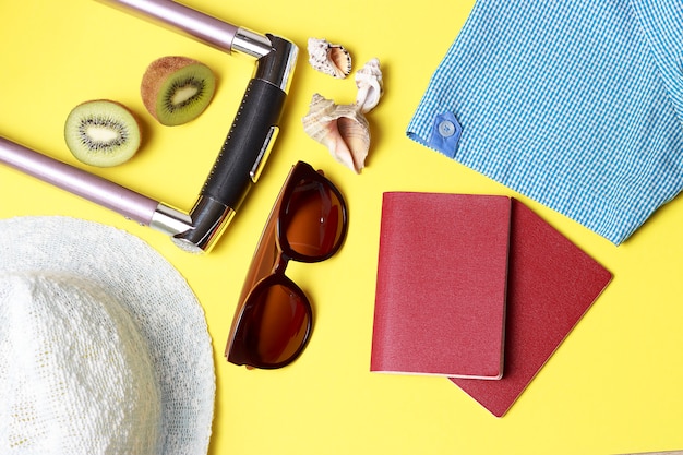 Accessoires de voyage sur une vue de dessus de fond jaune.