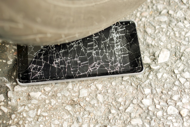 Accident de téléphone mobile CloseUp noir frappé par moto avec verre brisé sur route