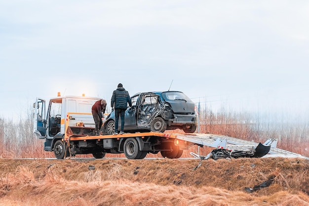 Accident de voiture TBone Side a écrasé une voiture familiale moderne, un camion de remorquage avec une voiture en panne sur une route, un camion d'émorquage transportant une voiture sur l'autoroute, le site d'un accident de voiture.