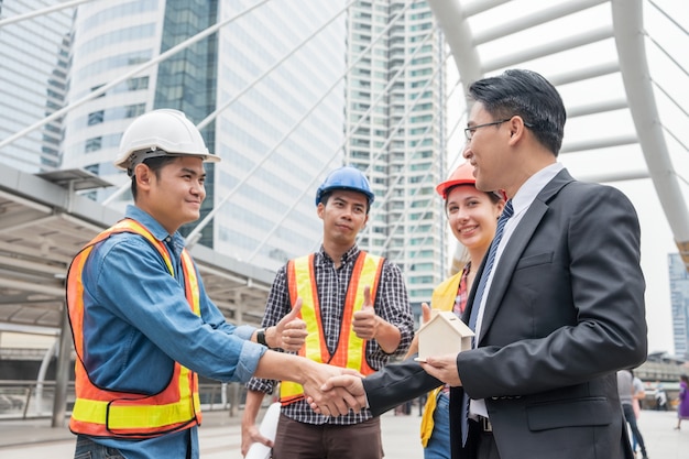 Accord de poignée de main de groupe d'ingénieur avec l'homme d'affaires pour la construction résidentielle de projet