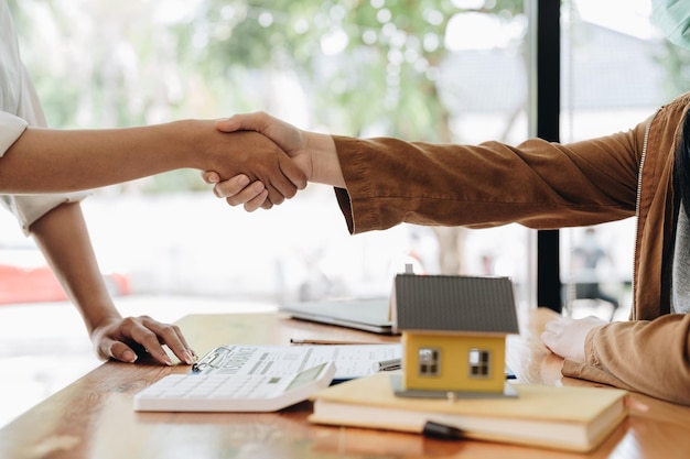 Photo accord réussi de l'acheteur du concept de contrat d'achat immobilier avec les employés de la banque après avoir terminé la signature du contrat au bureau