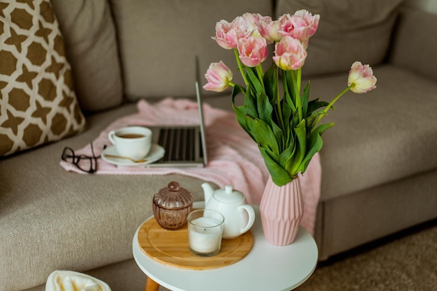 Accueil bureau confortable Travail à la maison Décor de printemps Couverture tricotée bouquet de tulipes thé chaud ordinateur portable Freelance