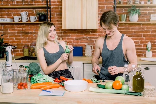 Accueil. Heureux ensemble. Mari et femme. Préparer la nourriture. Cuisine. Appartement. Naturel. Des légumes. S'aimer l'un l'autre. Maternité. Relaxation. Bonheur. La parentalité. La vie domestique.