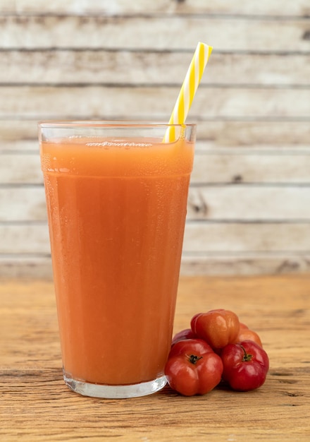 Acérolas ou jus de cerises de la Barbade avec fruits sur table en bois