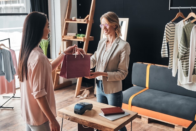 achats. belle jeune femme donnant un panier à son client