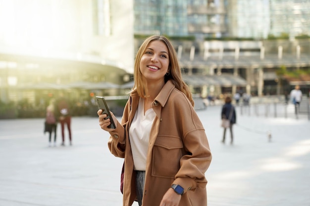 Achats du vendredi noir. Femme d'affaires marchant. Application mobile. Architecture moderne. Vêtements d'hiver. Fête de Noël. Les gens de la technologie.