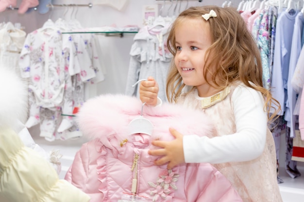 Achats. une fille ravie de tenir une veste