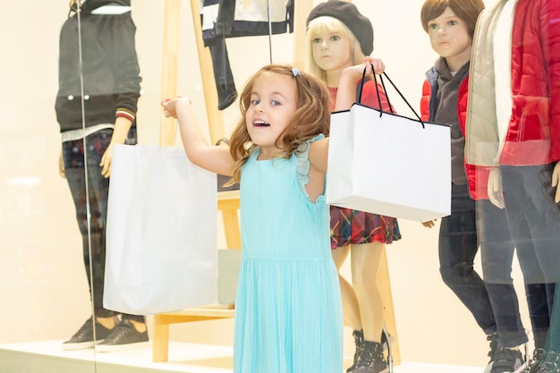 Achats. une fille avec des sacs à provisions en mains.