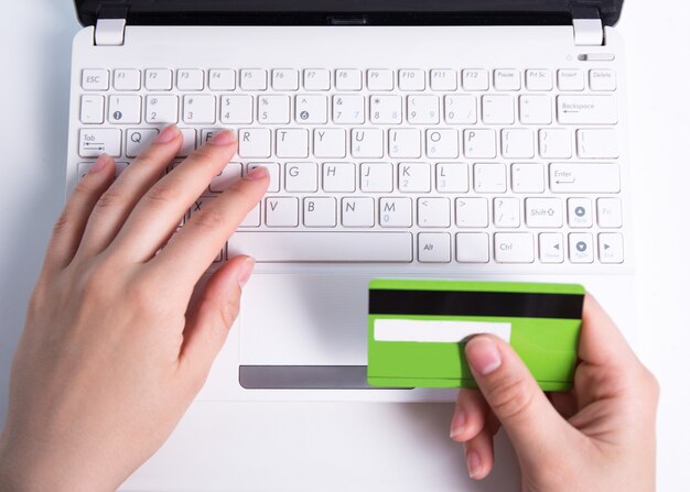 Achats en ligne - mains féminines avec carte de crédit et clavier d'ordinateur portable