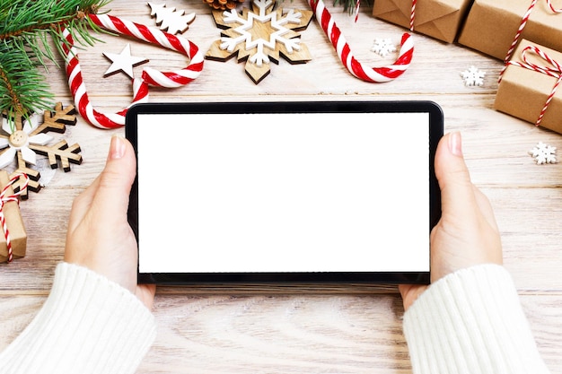 Photo achats en ligne de noël écran tactile de l'espace de copie de la tablette femme achète des cadeaux parmi des boîtes à cadeaux sur une table en bois blanc arrière-plan des ventes de vacances d'hiver