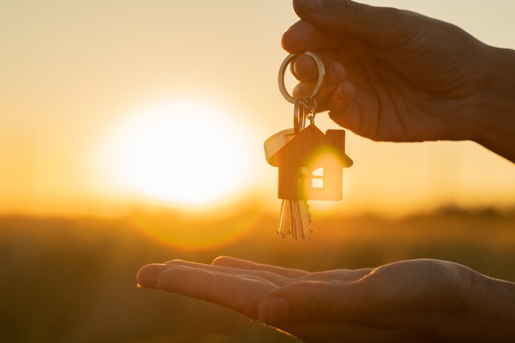 Photo acheter ou louer un concept de maison d'habitation une main de femme tient une clé avec un porte-clés en forme de...