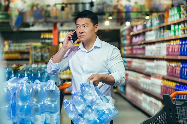 Un acheteur asiatique effrayé dans un supermarché achète des marchandises pénurie d'eau homme de crise économique et alimentaire