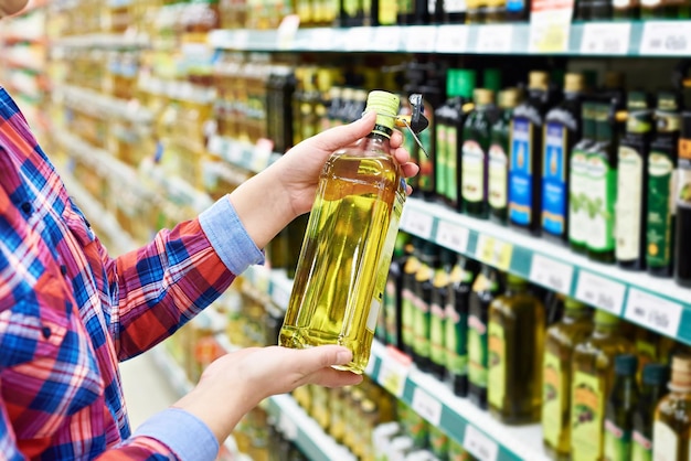 Acheteur avec l'huile de tournesol dans un magasin