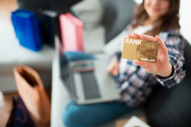 L'acheteur regarde l'écran et détient une carte de crédit. Une jeune femme utilise un ordinateur portable pour acheter de nombreux produits en ligne.