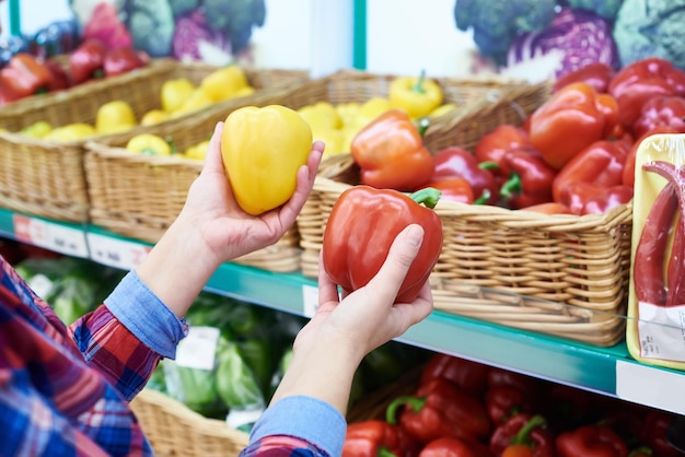 L'acheteur sélectionne les poivrons dans le magasin