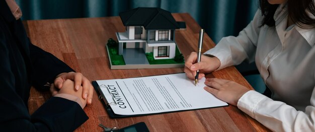 L'acheteur signe le papier du contrat de prêt avec un stylo sur le bureau Enthousiaste