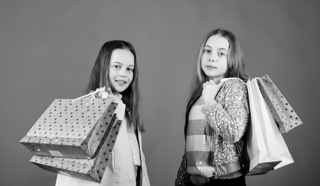 Acheteuse accro à la mode Boutique de mode pour enfants Shopping de ses rêves Enfants heureux dans une boutique avec des sacs Le shopping est la meilleure thérapie Le bonheur d'une journée de shopping Sœurs faisant du shopping ensemble Acheter des vêtements