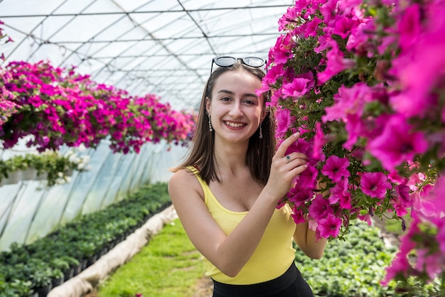 Une acheteuse choisit de belles fleurs dans une serre