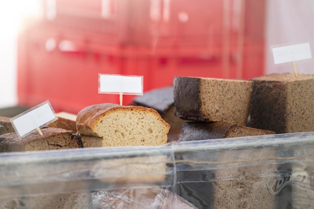 Achetez du pain au magasin du pain noir et blanc sur le comptoir de la boulangerie en achetant du pain frais ensemencé noir r