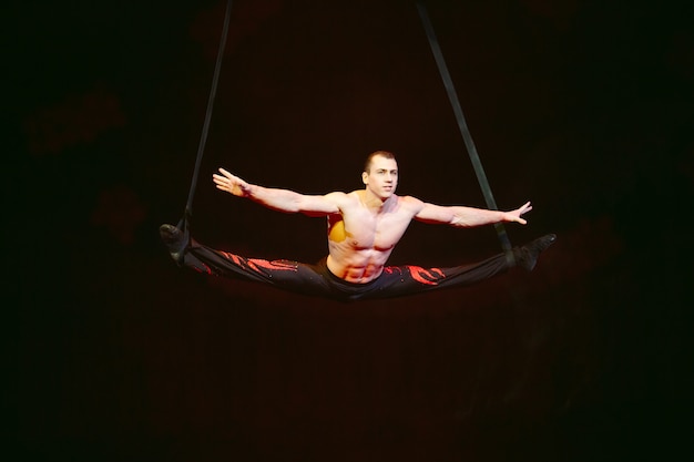 Acrobat exécute un tour difficile dans le cirque.