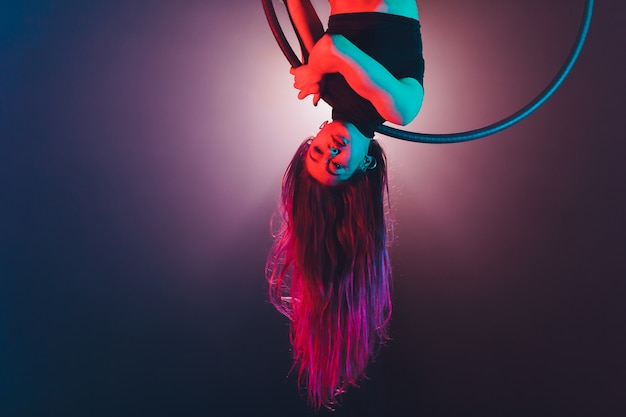 Acrobate aérien dans le ring. Une jeune fille exécute les éléments acrobatiques dans l'anneau aérien.