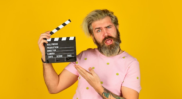 Acteur casting Scène de tournage Série préférée Action Production cinématographique Producteur créatif Un homme barbu tient un battant de film Concept de réalisation de film Clapperboard copiez l'espace Regarder un film Réalisateur