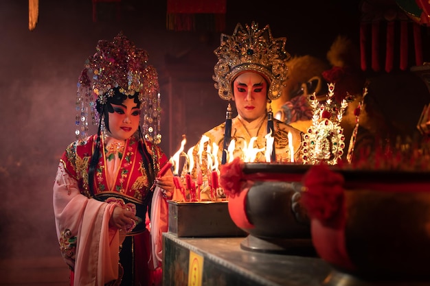 Les acteurs et actrices d'opéra chinois allument une bougie pour prier l'hommage aux dieux pour améliorer