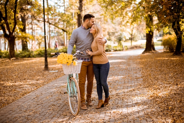 Actif jeune couple jouir ensemble à vélo dans le parc automne doré