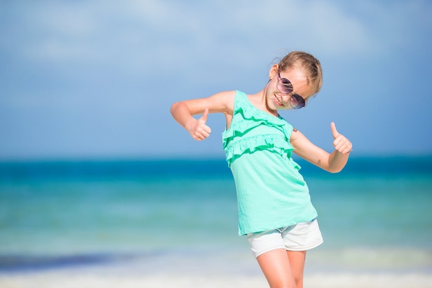 Actif petite fille sur la plage blanche s'amuser. Closeup kid fond la mer