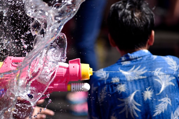 Action de congélation du mur d'eau et du pistolet à eau tout en crachant un jet d'eau le jour de Songkran