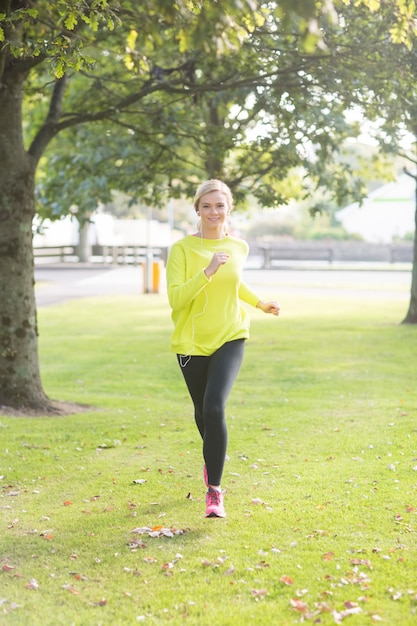 Active blonde souriante jogging vers la caméra