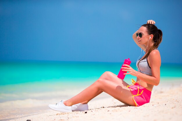 Active fit jeune femme dans ses vêtements de sport pendant les vacances à la plage