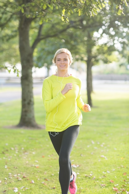 Active heureuse blonde jogging vers la caméra