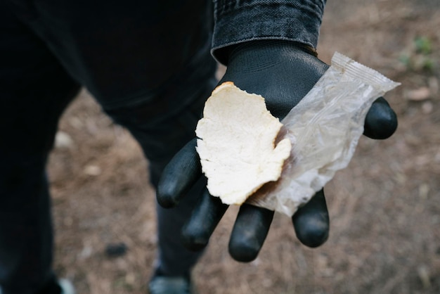 Activiste montrant des ordures trouvées dans la forêt lors de la collecte solidaire