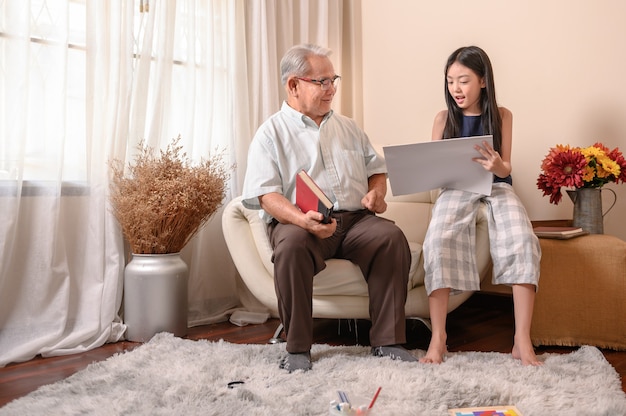 Activité grand-père et petite-fille à la maison. Mode de vie à l'âge de la retraite en famille pendant les vacances d'été.