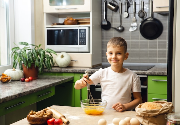 Activité intérieure. Garçon jeune enfant cuisine dans la cuisine. Faire des gâteaux ou des biscuits