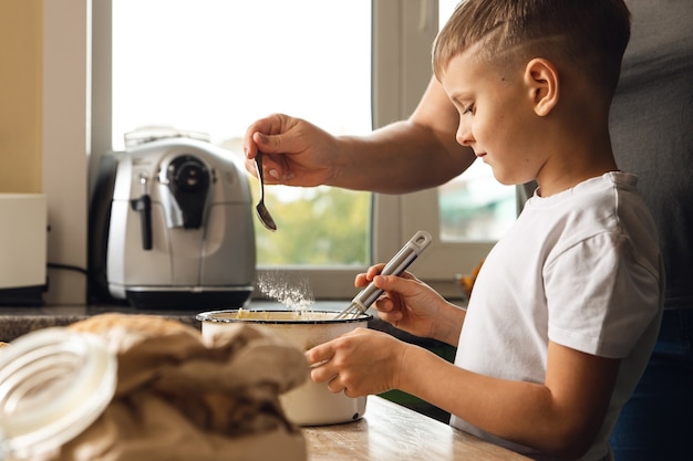 Activité intérieure. Garçon jeune enfant cuisine dans la cuisine avec la mère. Faire des gâteaux ou des biscuits