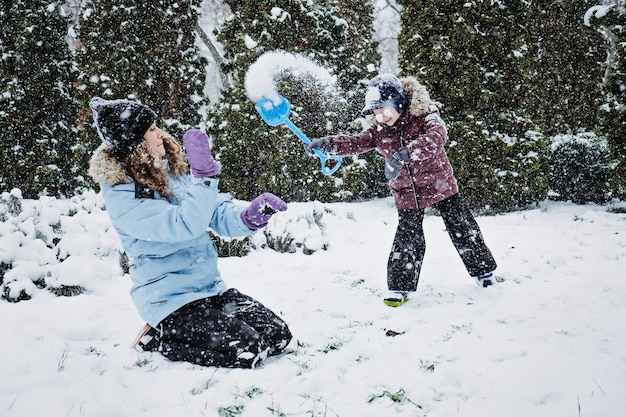 Activités d'hiver en plein air pour les enfants et la famille, laissez-le neiger, mère de famille heureuse et garçon s'amusant