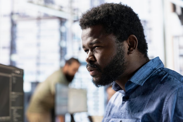 Admin squinting eyes trying to better see while reading source code on computer doing software