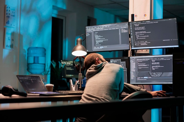 Administrateur de base de données tapant le code de programmation sur ordinateur avec plusieurs moniteurs, travaillant avec un script html. Développement d'algorithmes pour l'intelligence artificielle sur terminal window, cloud computing.