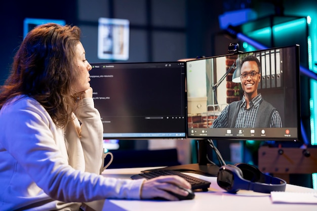 Administrateur effectuant le débogage des logiciels de l'entreprise parlant avec la direction dans un appel vidéo
